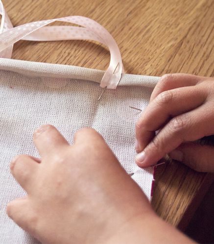 enfant réalisant un travail de couture enfant réalisant un travail de couture